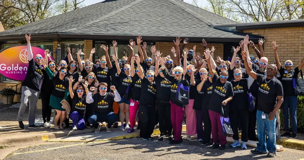 Golden Years Marlin Texas team photo celebrating positive snf outcomes Golden Years employees posing outside a nursing facility with their hands raised in celebration.
