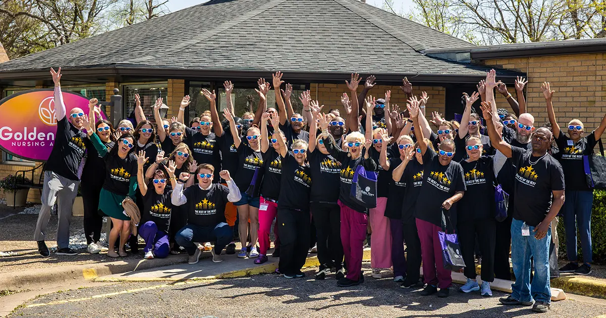 Golden Years Marlin Texas team photo celebrating positive snf outcomes Golden Years employees posing outside a nursing facility with their hands raised in celebration.
